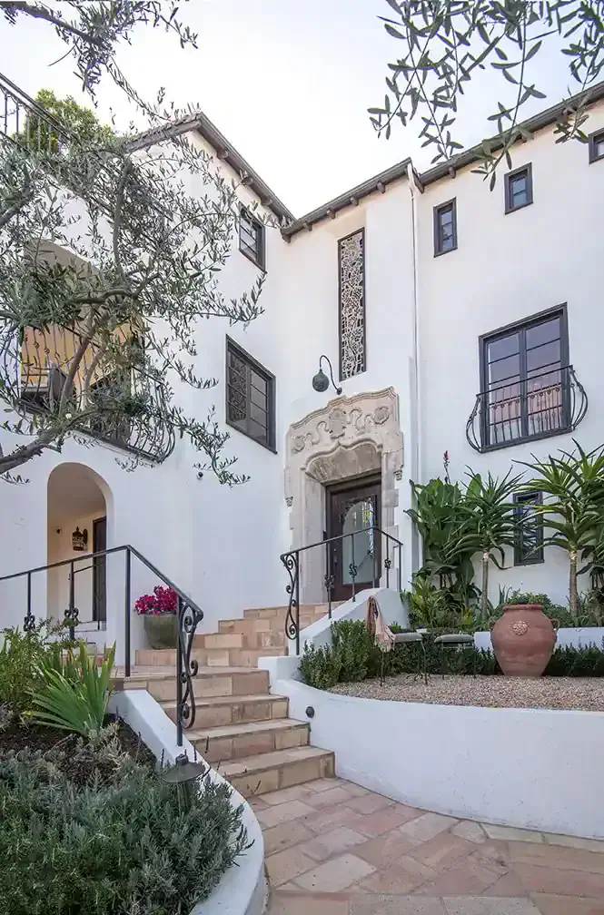   The back terrace holds a custom Cedar dining table and dining chairs by Palecek. Photos by Nolasco Studios.   