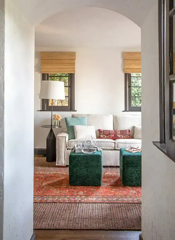  The TV room has a custom sofa covered in Pindler fabric and custom coffee table ottomans. The rug is from Patterson Flynn & Martin. Photos by  Nolasco Studios.  