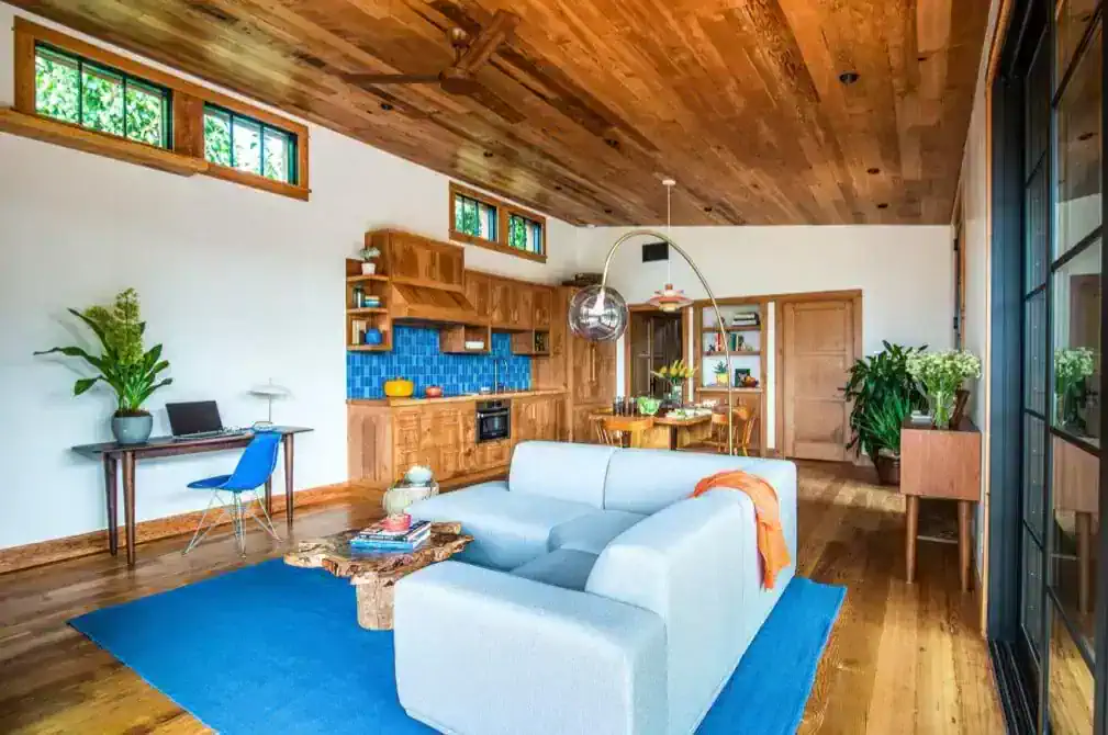   Having a large common space that comprises the living, dining, and kitchen areas makes the room feel larger, while thermal sliding doors on one side let in light and air.   